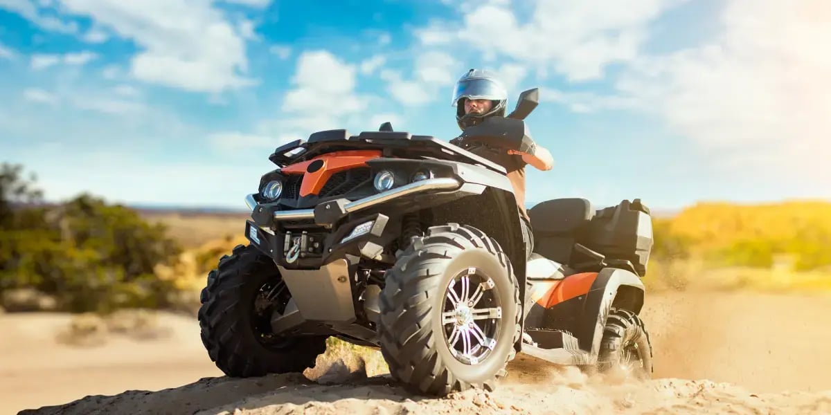 Woman Rides ATV Through Sandy Desert Landscape
