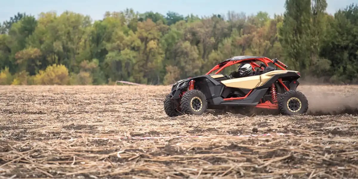 Quad bike is racing at high speed along an oblique field