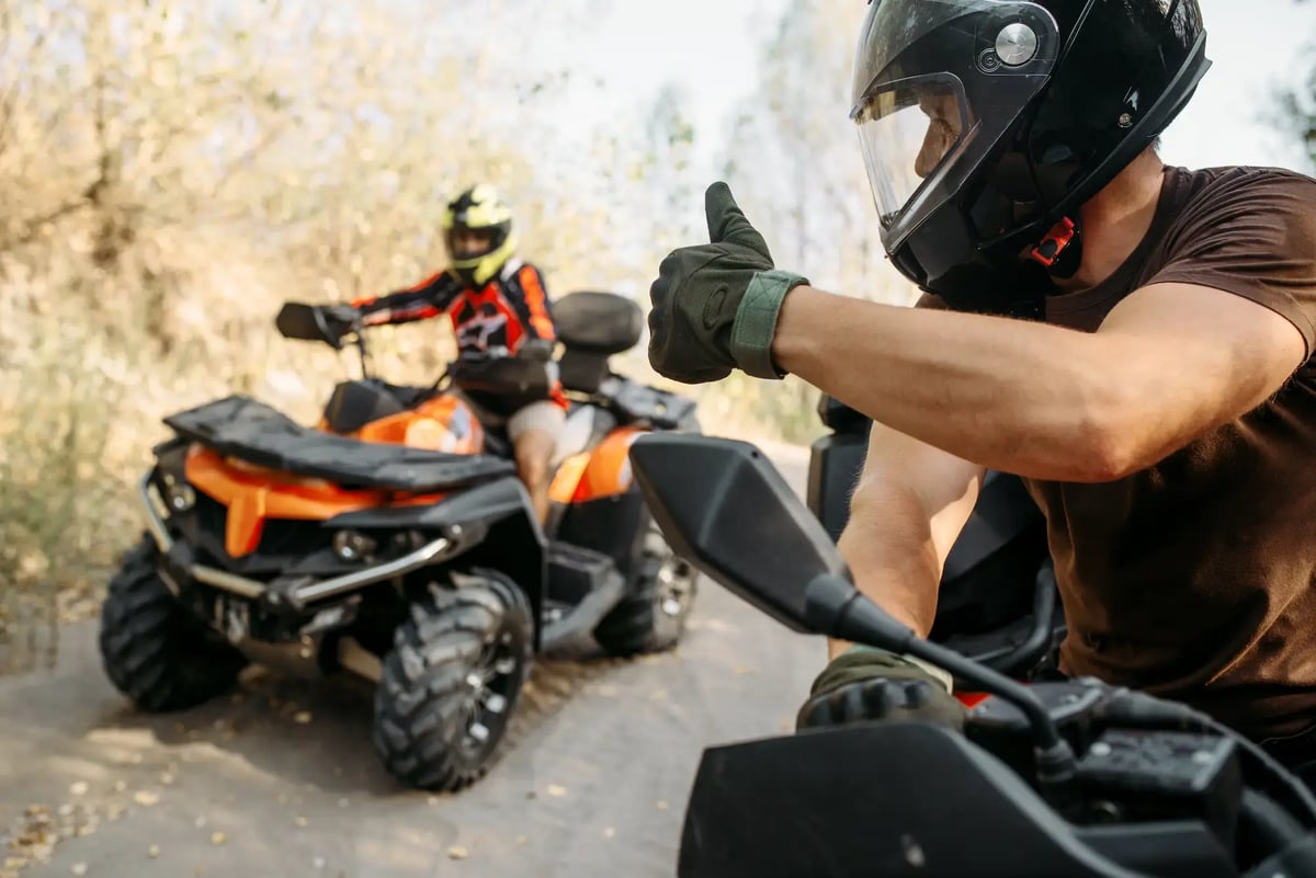 Enthusiastic-riders-giving-a-thumbs-up-on-atvs