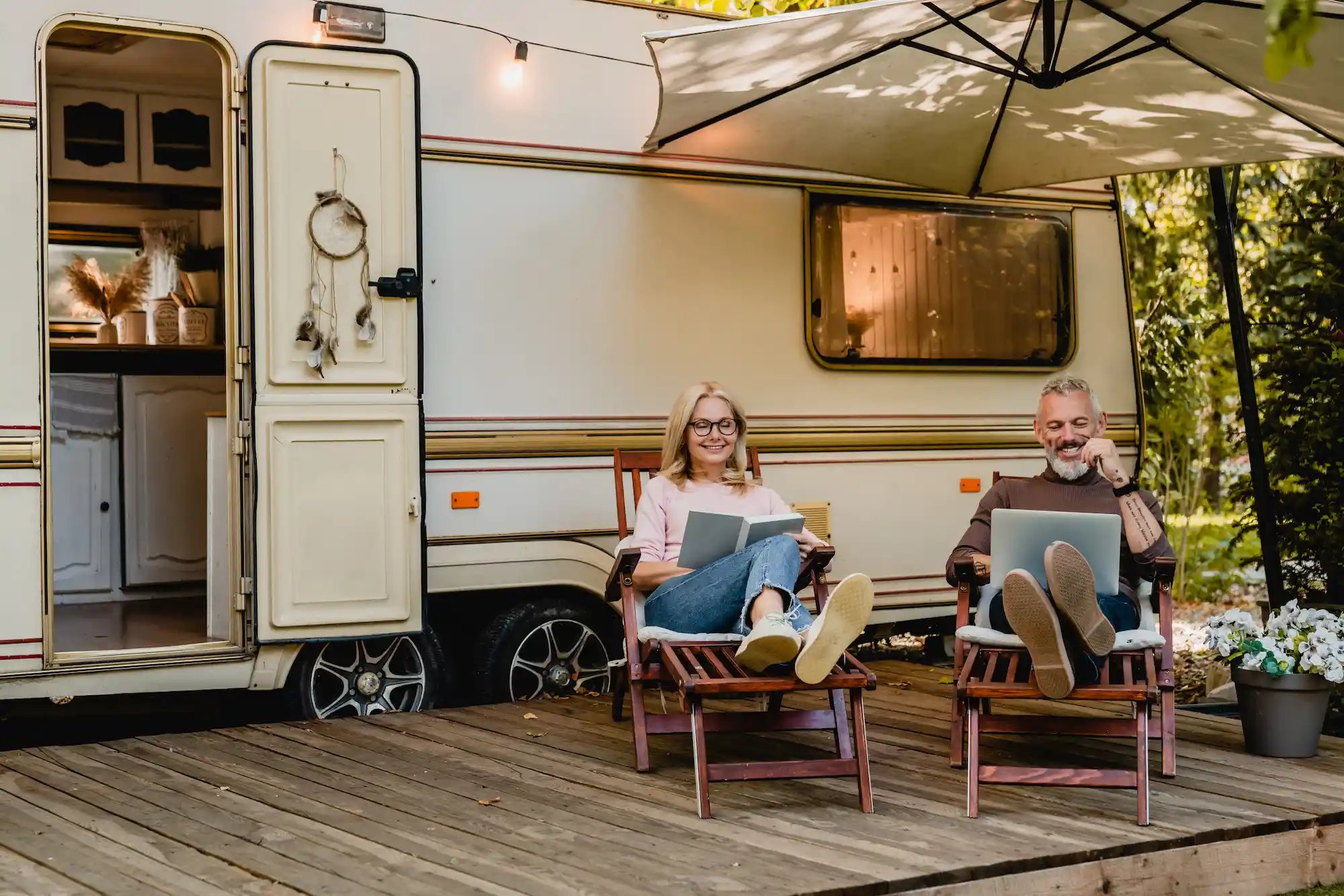 mature-couple-relaxing-outside-of-camper-on-deck-